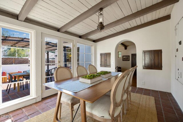 dining space with french doors, lofted ceiling with beams, and wooden ceiling