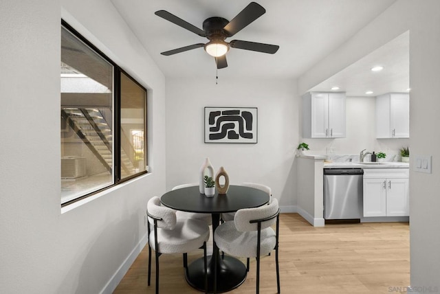 dining area featuring sink, light hardwood / wood-style flooring, and ceiling fan