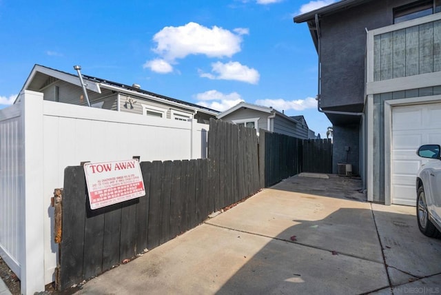 view of side of property with a garage and central AC unit