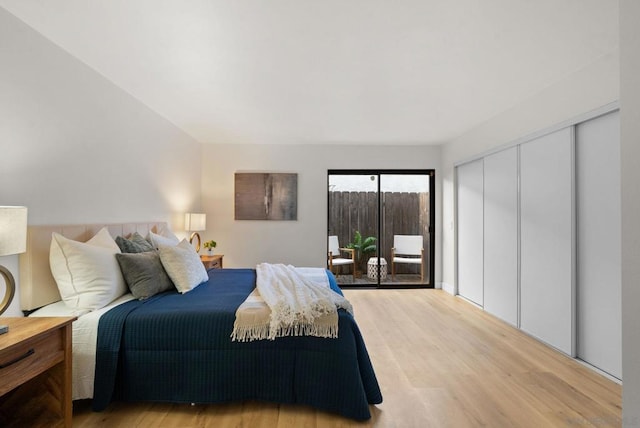 bedroom with access to exterior, wood-type flooring, and a closet