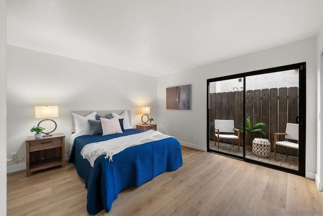 bedroom with access to exterior and light hardwood / wood-style floors