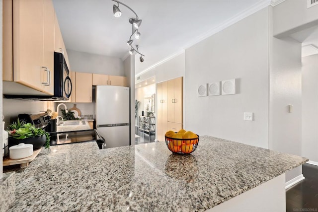 kitchen with crown molding, white refrigerator, light stone counters, light brown cabinetry, and kitchen peninsula