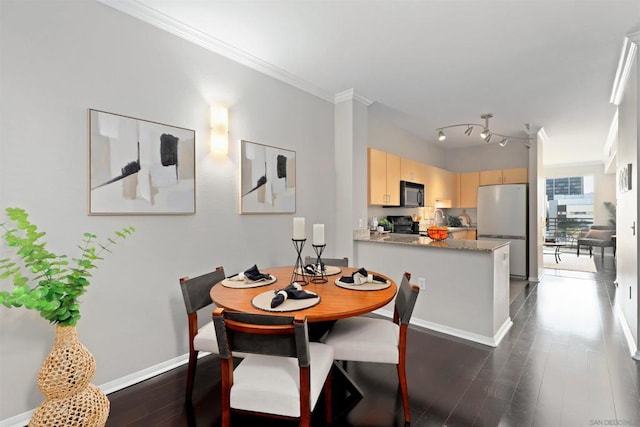 dining area featuring dark hardwood / wood-style flooring, track lighting, and ornamental molding