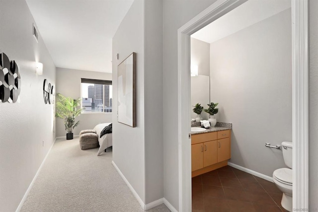 hall with dark carpet and sink