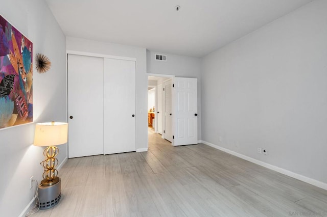 unfurnished bedroom with light hardwood / wood-style floors and a closet