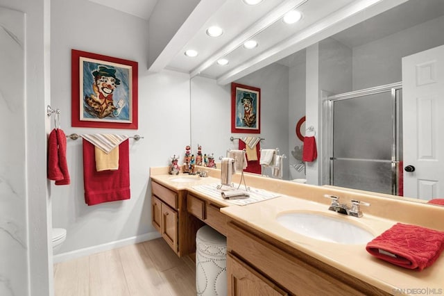 bathroom featuring a shower with door, vanity, hardwood / wood-style flooring, and toilet