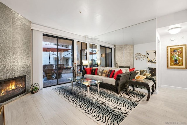 living room with a large fireplace and light hardwood / wood-style flooring