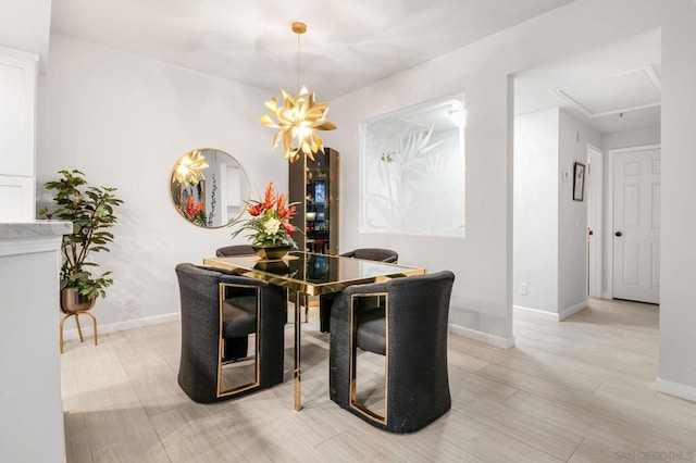 dining space with light hardwood / wood-style floors and a notable chandelier