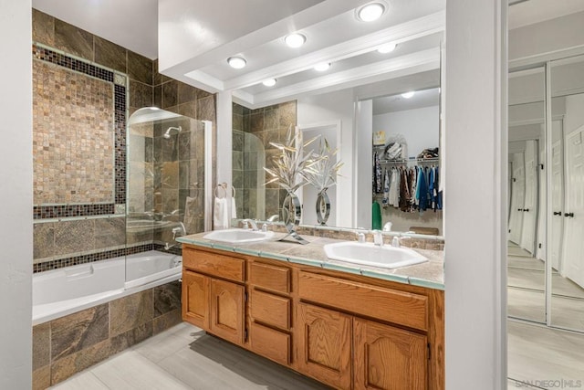 bathroom with tiled shower / bath combo and vanity