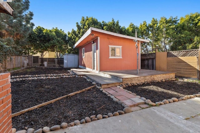 view of side of home with a wooden deck and a storage unit