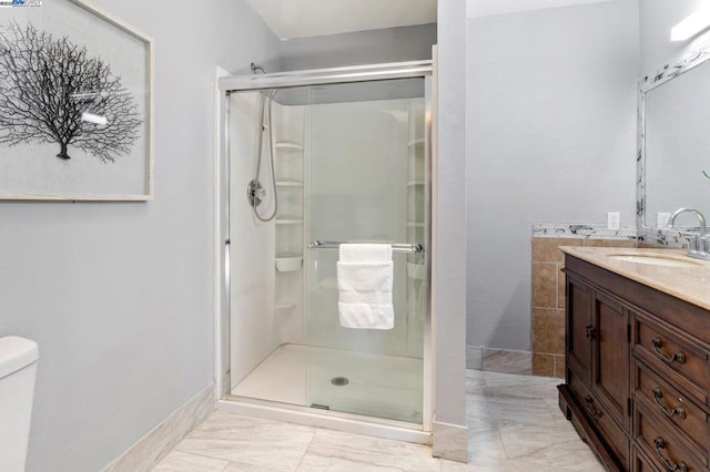 bathroom with an enclosed shower, vanity, and toilet