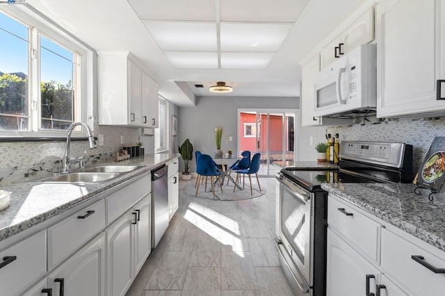 kitchen with stainless steel appliances, sink, and white cabinets