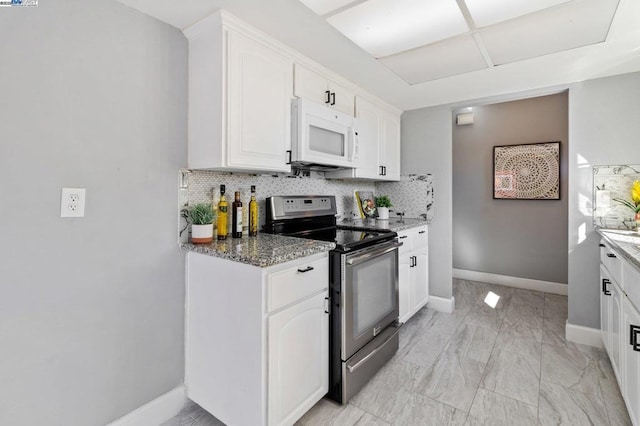 kitchen featuring tasteful backsplash, stainless steel electric stove, dark stone countertops, and white cabinets