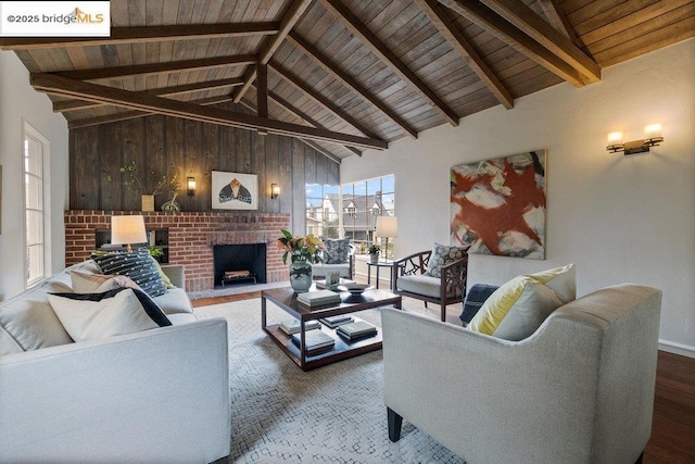 living room with wood ceiling, wood-type flooring, lofted ceiling with beams, a brick fireplace, and wood walls