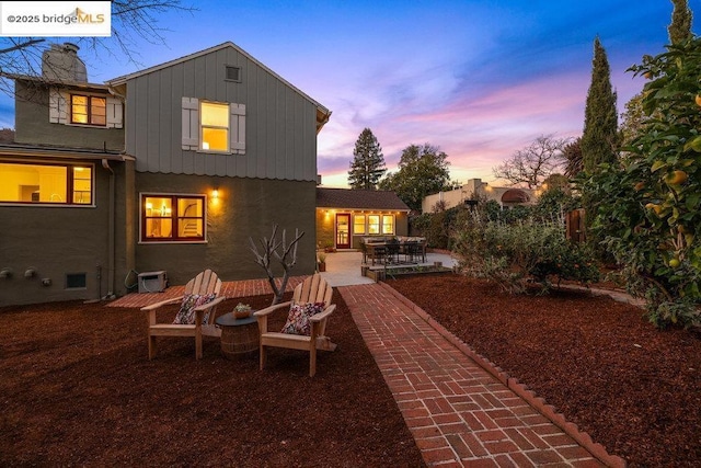 back house at dusk with a patio