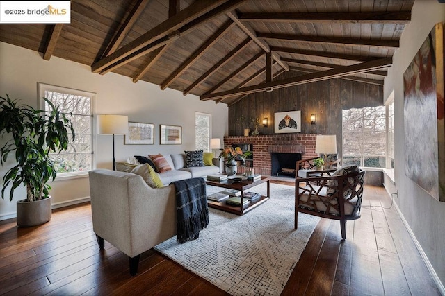 living room featuring a brick fireplace, beam ceiling, wood-type flooring, and wooden ceiling