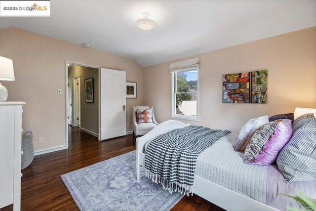 bedroom with lofted ceiling and dark hardwood / wood-style floors