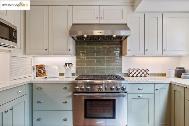 kitchen with extractor fan, appliances with stainless steel finishes, and backsplash