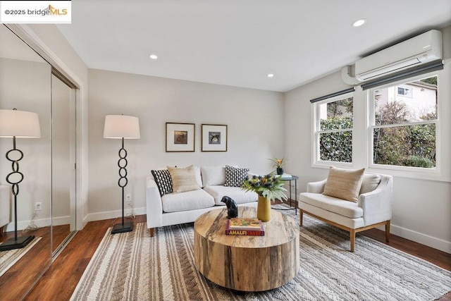 living room with a wall mounted AC and dark hardwood / wood-style flooring