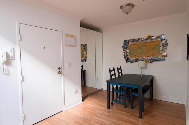 dining area featuring crown molding and light hardwood / wood-style floors