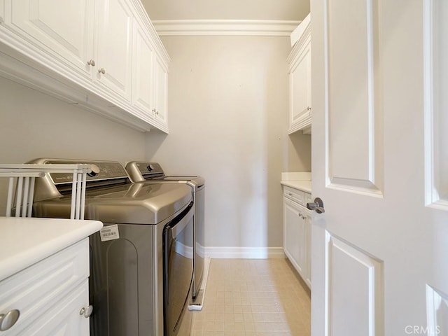 laundry area featuring crown molding, cabinets, light tile patterned floors, and washing machine and clothes dryer