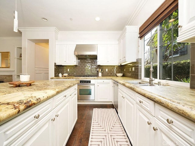 kitchen featuring white cabinets, appliances with stainless steel finishes, light stone countertops, and wall chimney range hood