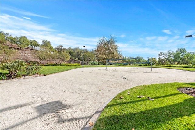 view of property's community featuring a yard and volleyball court