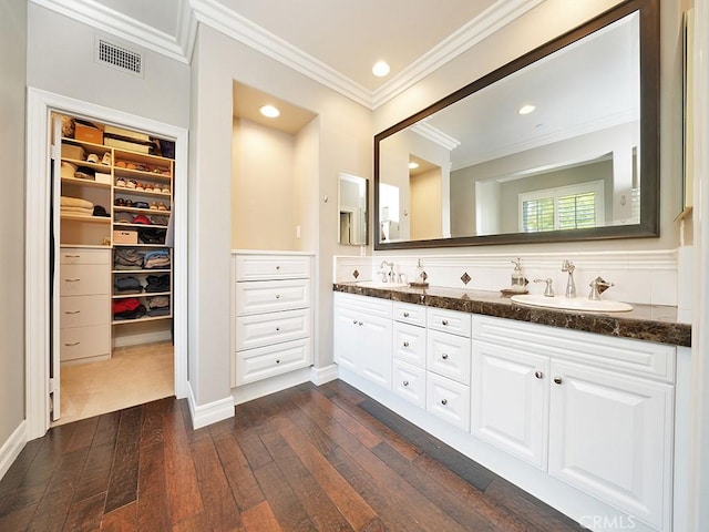 bathroom featuring vanity, wood-type flooring, and ornamental molding