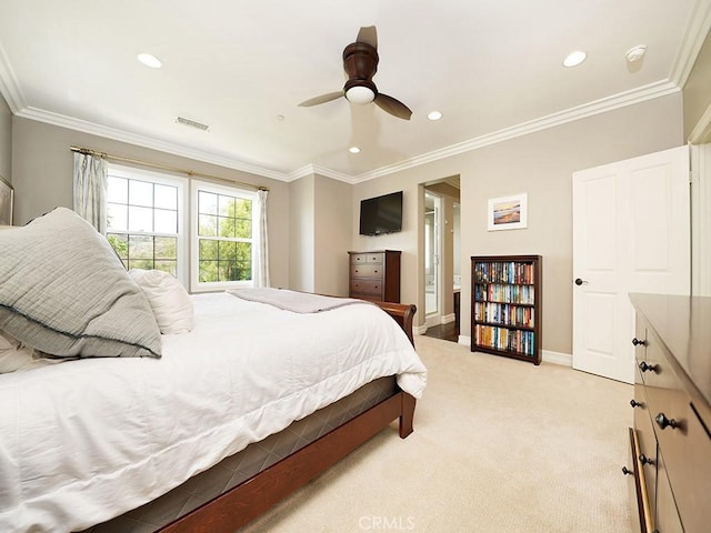 bedroom featuring light carpet, connected bathroom, crown molding, and ceiling fan