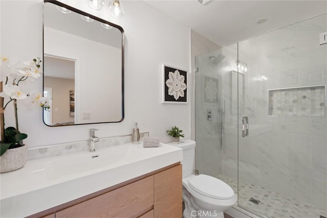 bathroom with vanity, toilet, and a shower with shower door