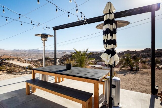 view of property's community with a mountain view and a patio