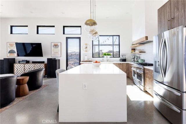 kitchen featuring decorative light fixtures, stainless steel appliances, custom range hood, and a kitchen island