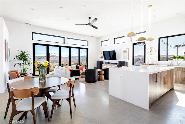 kitchen with pendant lighting, a center island, ceiling fan, and a high ceiling