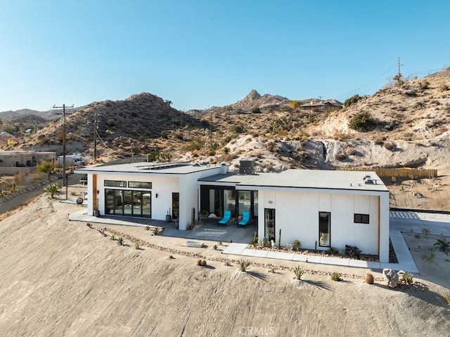 back of property with a patio and a mountain view