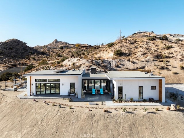 rear view of property with a mountain view and a patio