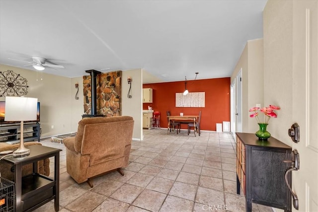 living room featuring a wood stove and ceiling fan