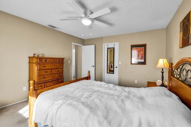 carpeted bedroom with ceiling fan and a textured ceiling