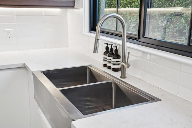 interior details featuring sink and decorative backsplash