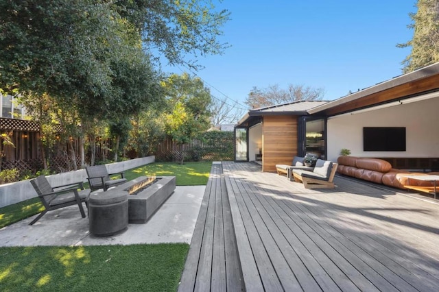 wooden deck featuring a patio, a lawn, and an outdoor fire pit