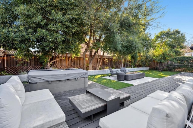 deck with a hot tub and an outdoor living space with a fire pit