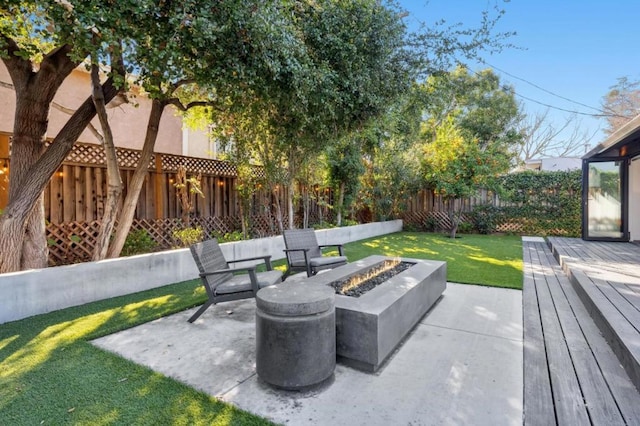 view of patio with a wooden deck and a fire pit