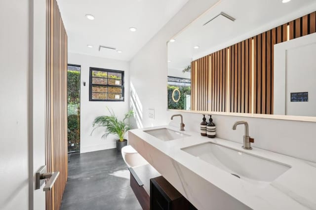 bathroom featuring vanity, concrete flooring, and toilet