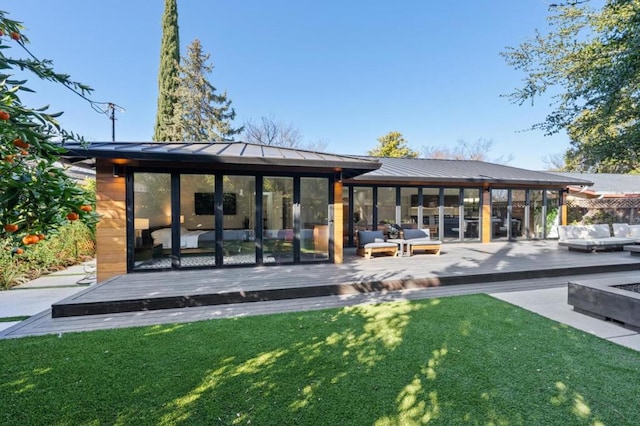 back of house featuring a wooden deck and a yard