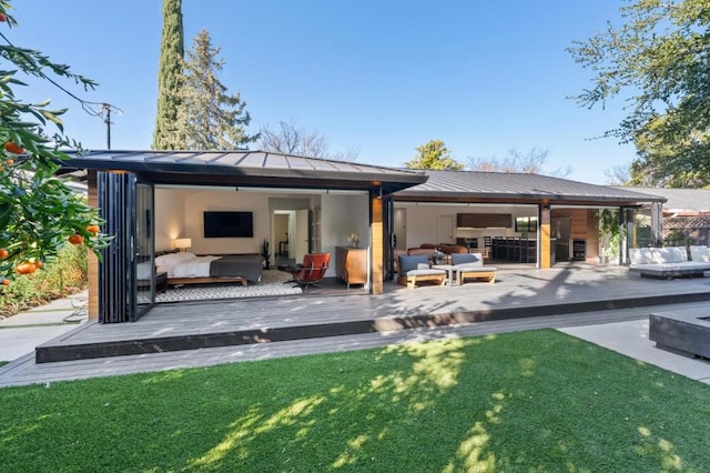 back of house featuring a wooden deck, an outdoor living space, and a lawn