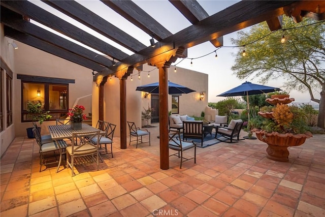 patio terrace at dusk featuring an outdoor hangout area and a pergola