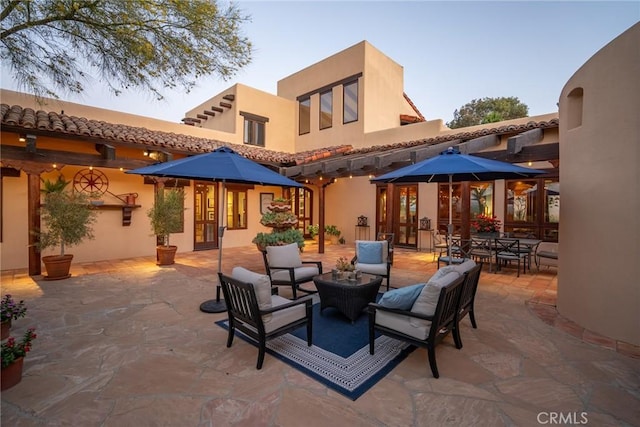 rear view of property with an outdoor living space and a patio area