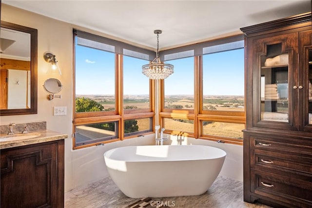 bathroom featuring vanity, a bathtub, and an inviting chandelier