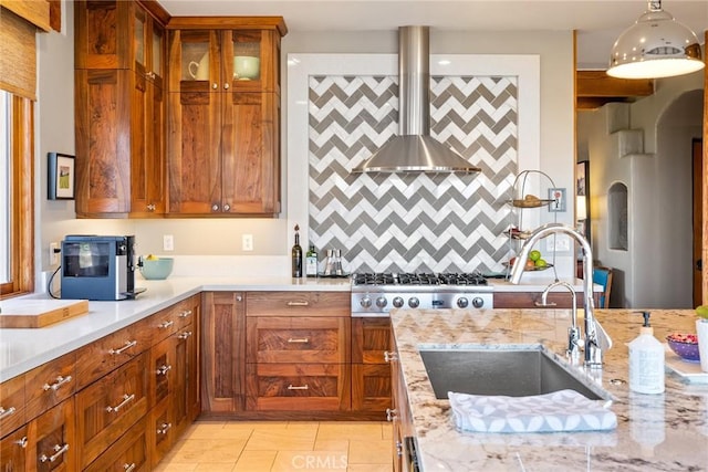 kitchen with sink, light stone counters, ventilation hood, stainless steel gas cooktop, and light tile patterned flooring