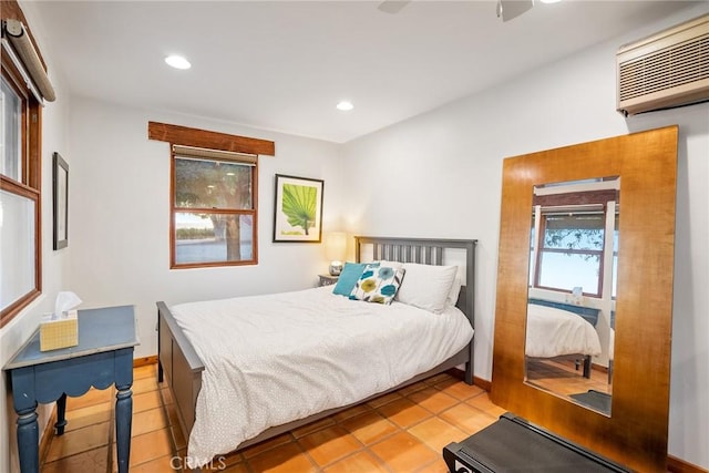 tiled bedroom with ceiling fan and a wall unit AC