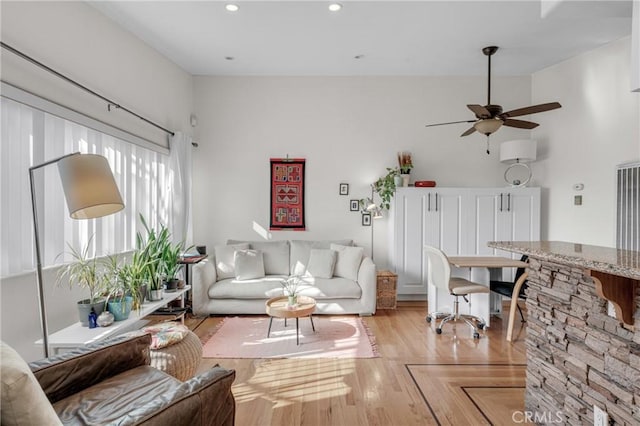 living room featuring light hardwood / wood-style flooring and ceiling fan